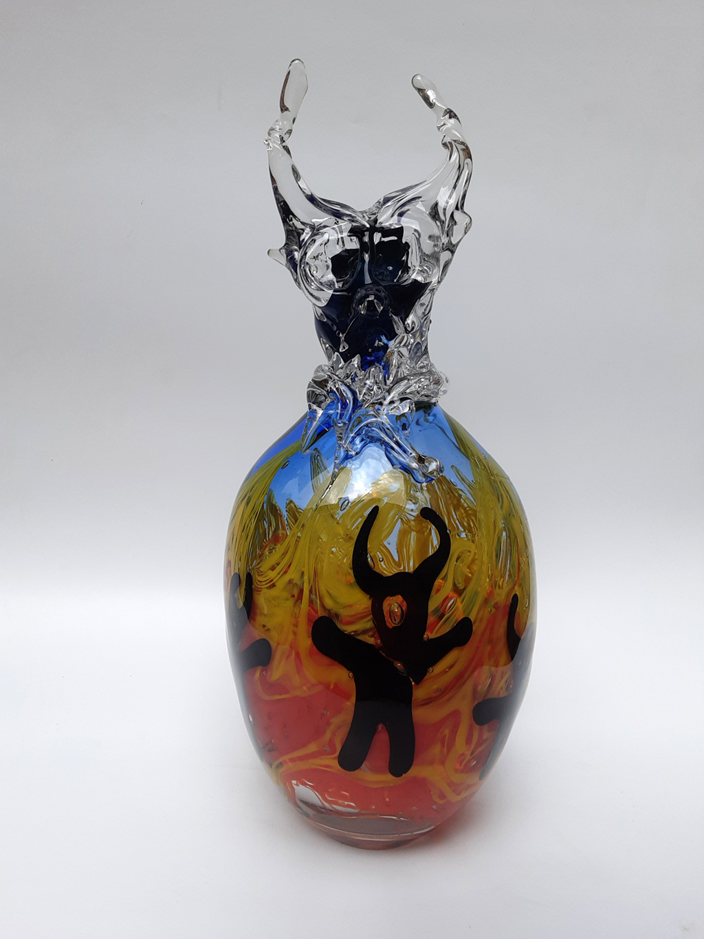 Glasobjekt in Feuerfarben mit schwarzer Teufelsfigur und Teufelskopf schwarz/klar