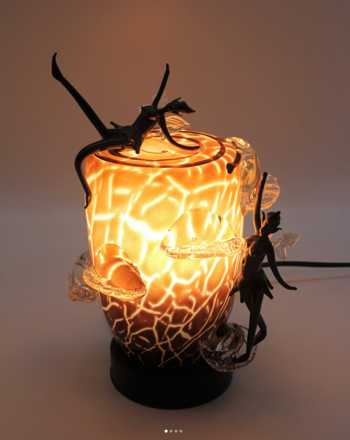 Leuchtendes Glasobjekt mit schwarzen Figuren leuchtendes Glasobjekt mit Figuren